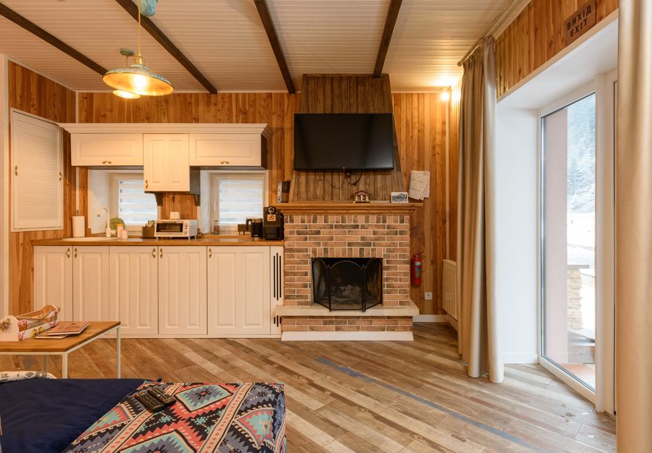 Interior de madera con chimenea y cocineta